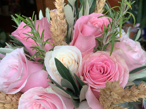 Bonita composición de rosas rosa y blancas, compuestas con espigas, olivo y romero