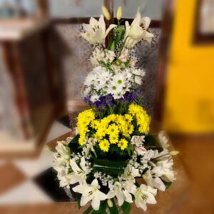 Centro de flores en escala con tonos blancos y amarillos